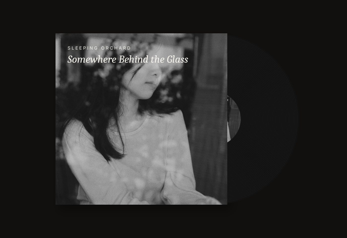 Vinyl sleeve mock-up: a woman seen through a café window, reflections of plants over her face, with the fictional title Somewhere Behind the Glass